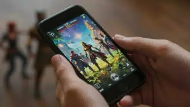 Um close-up das mãos de um adulto segurando um smartphone na horizontal, com um jogo de fantasia épico e vibrante na tela, mostrando uma cena de batalha intensa.
