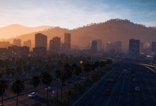 Vista ampla de Los Santos ao entardecer, com carros percorrendo uma avenida, palmeiras, edifícios e as colinas ao fundo, evocando o mundo aberto de GTA 5.